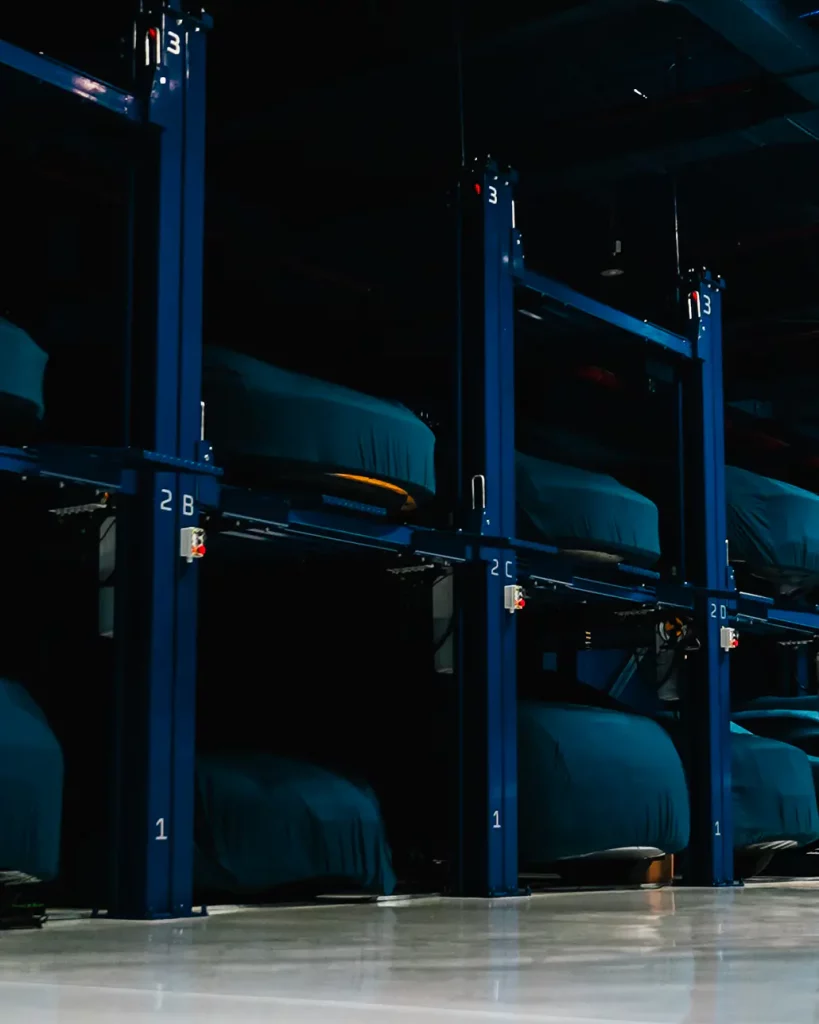 A collector car parked inside the sealed, climate-controlled storage hall at The Collectors Hangar in Dubai, lit low against dark walls
